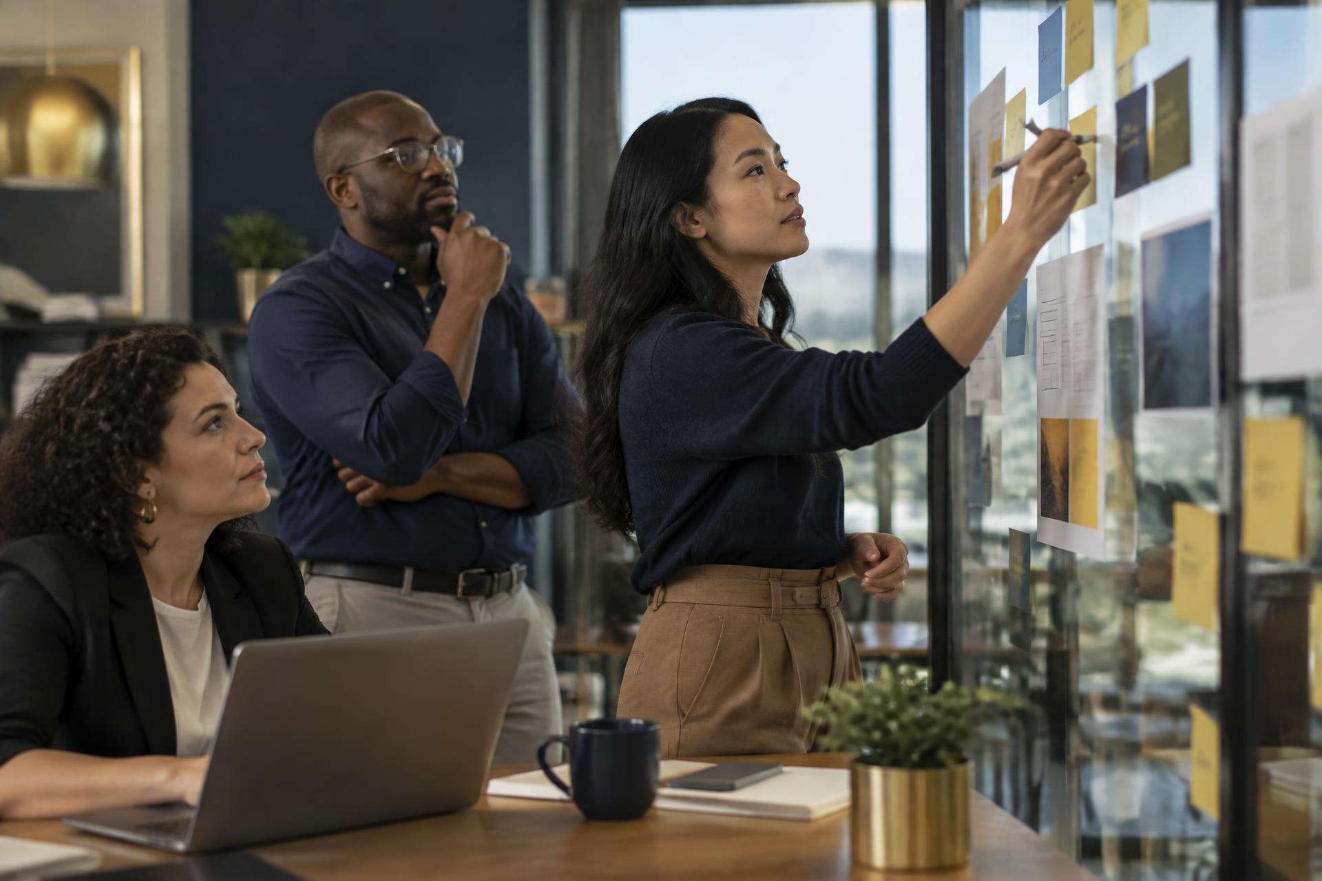 HR team mapping a workflow with sticky notes and policy pages on a glass wall